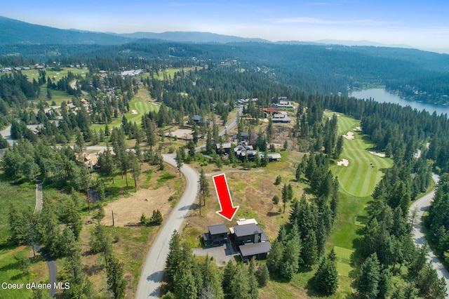 birds eye view of property with a water and mountain view and a wooded view