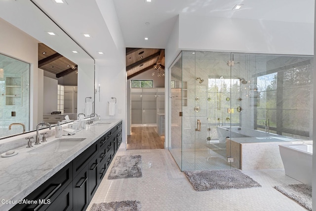 bathroom with double vanity, a freestanding tub, tile patterned floors, a sink, and a stall shower