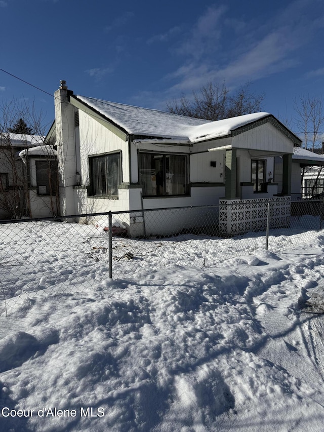 view of front of home with a fenced front yard and a chimney