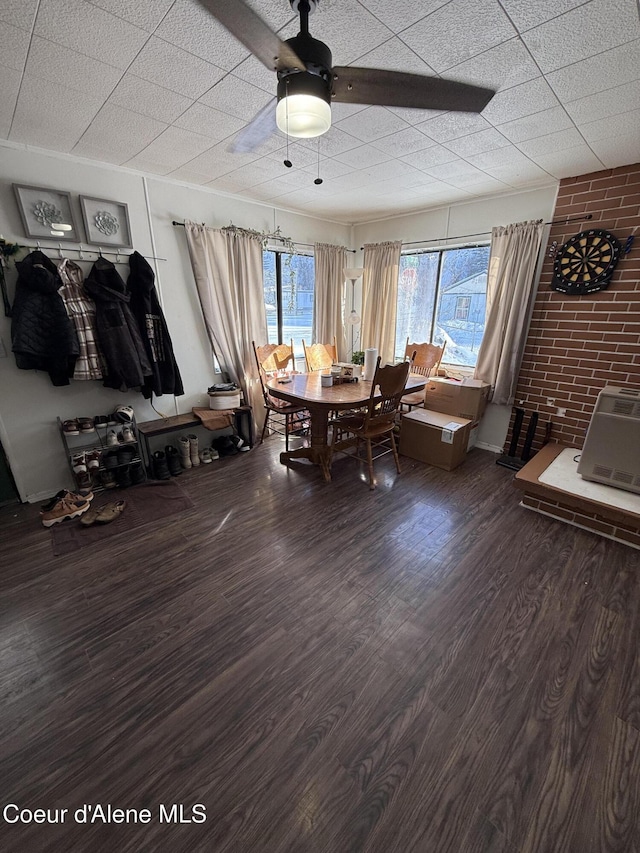 dining space featuring brick wall and wood finished floors