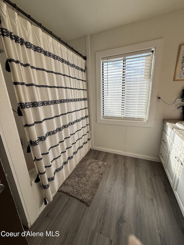 bathroom with baseboards, vanity, a shower with curtain, and wood finished floors