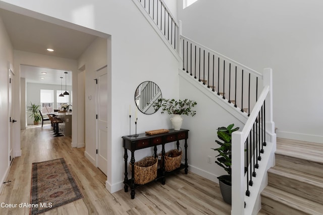 staircase featuring recessed lighting, baseboards, and wood finished floors