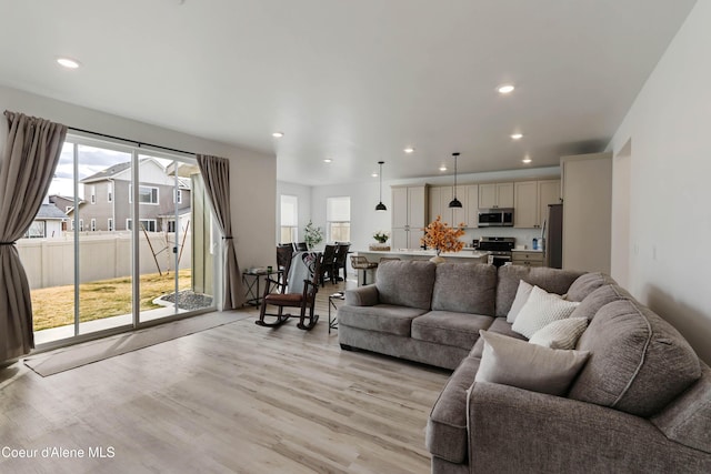 living area with recessed lighting and light wood finished floors