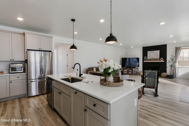 kitchen with light wood-style flooring, a sink, freestanding refrigerator, light countertops, and dishwasher