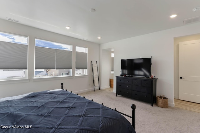 carpeted bedroom featuring multiple windows, baseboards, and visible vents