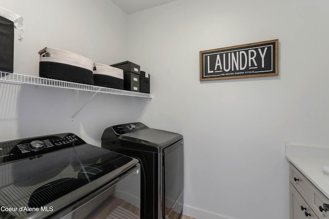 washroom with cabinet space, separate washer and dryer, and baseboards