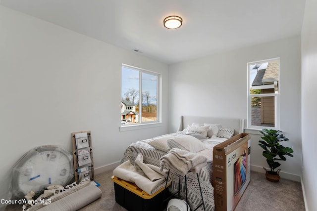 carpeted bedroom featuring baseboards and visible vents