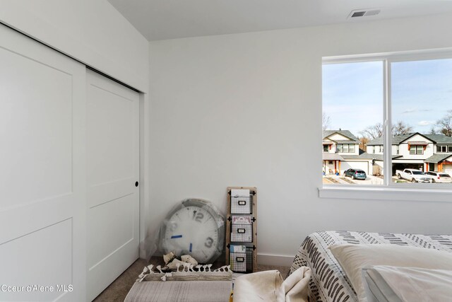 bedroom featuring visible vents, baseboards, carpet, and a closet