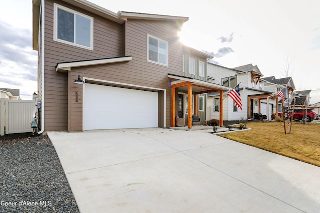 view of front of house with a balcony, fence, concrete driveway, a front lawn, and a garage