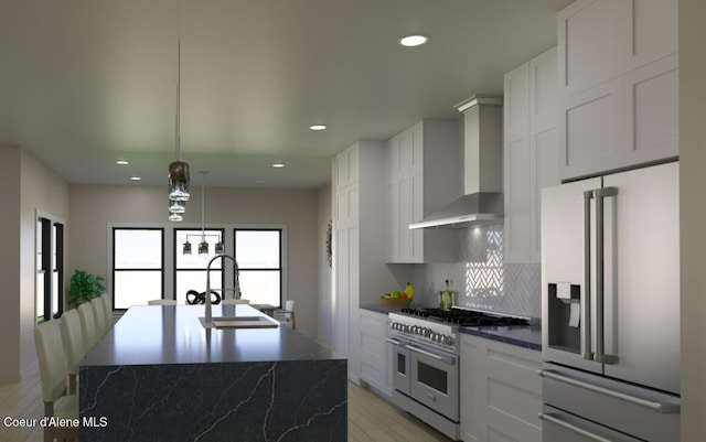 kitchen with a sink, appliances with stainless steel finishes, wall chimney exhaust hood, and recessed lighting