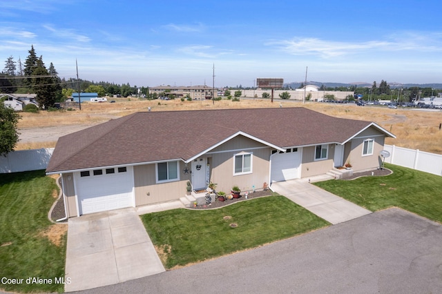 ranch-style home featuring fence, roof with shingles, concrete driveway, a front yard, and an attached garage