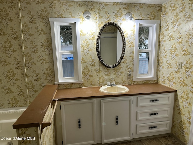 bathroom featuring wallpapered walls and vanity