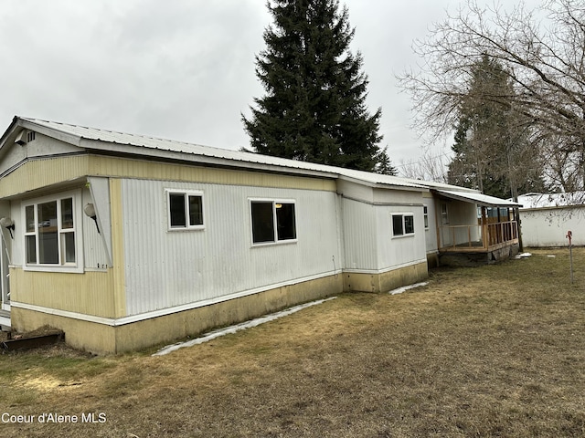 view of property exterior featuring a lawn and metal roof