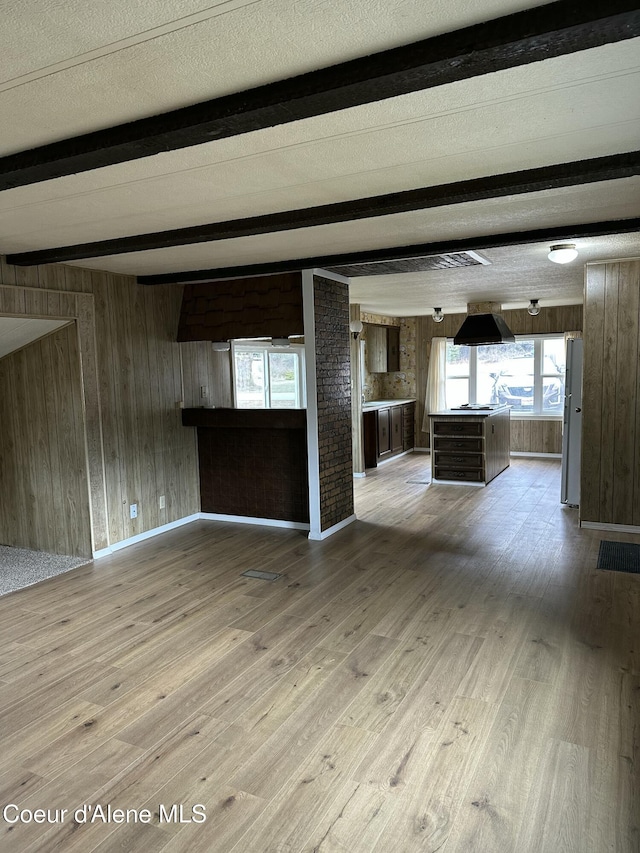 608 S Meadowdale Ave, Oldtown, ID 83822 - unfurnished living room with baseboards, beamed ceiling, wood walls, and wood finished floors
