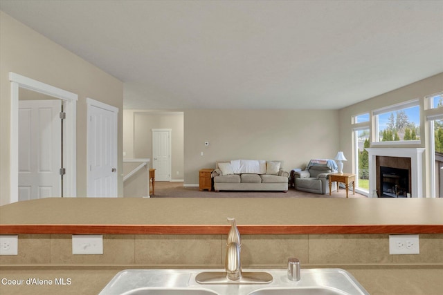 kitchen featuring a sink, open floor plan, and a fireplace