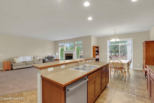 kitchen with dishwasher, a fireplace, open floor plan, and a sink