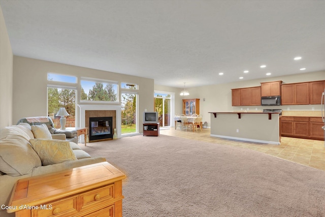 living room featuring a fireplace, recessed lighting, light colored carpet, and light tile patterned floors