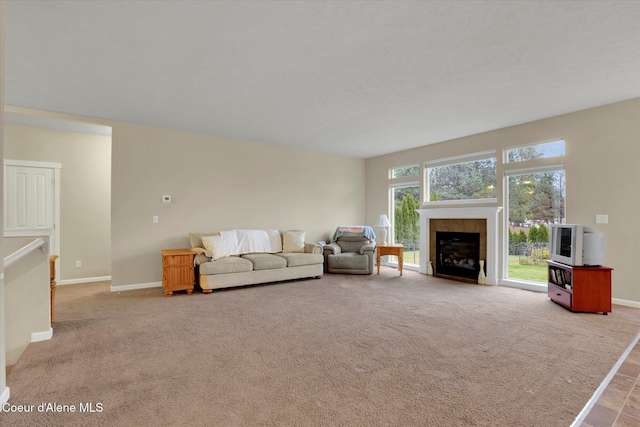 unfurnished living room featuring carpet flooring, a fireplace, and baseboards