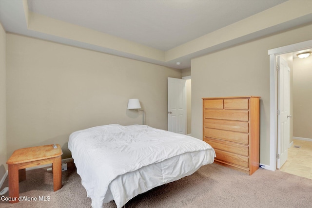 bedroom featuring light colored carpet and baseboards