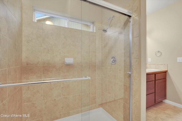 bathroom featuring baseboards, a stall shower, and vanity