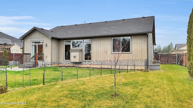 view of front of home with a fenced backyard, a front yard, and roof with shingles