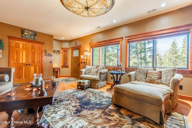 living room with recessed lighting, wood finished floors, and visible vents