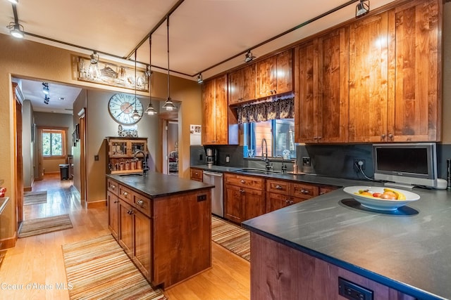 kitchen featuring dishwasher, dark countertops, and brown cabinets