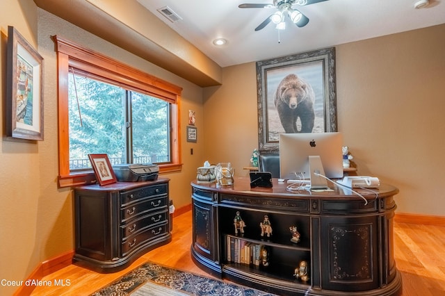 office space featuring visible vents, baseboards, light wood-style floors, and a ceiling fan