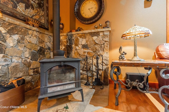 interior details featuring a wood stove and wood finished floors