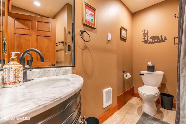 bathroom featuring visible vents, toilet, lofted ceiling, baseboards, and vanity