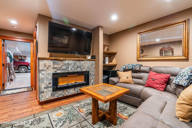 living area featuring a tiled fireplace, recessed lighting, and wood finished floors