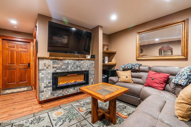 living area with recessed lighting, a fireplace, and wood finished floors