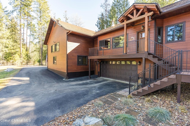 view of front of house with aphalt driveway, stairway, and an attached garage