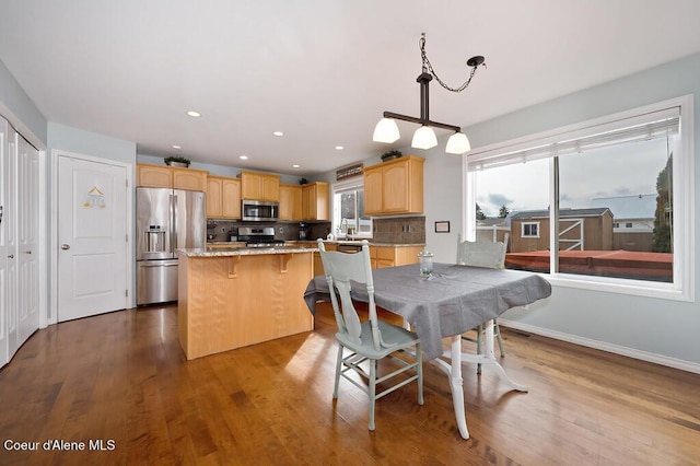 dining room featuring recessed lighting, wood finished floors, and baseboards