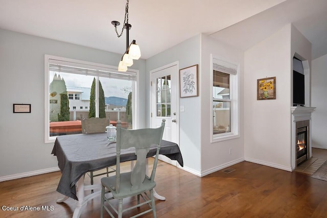 dining room featuring visible vents, baseboards, wood finished floors, and a chandelier