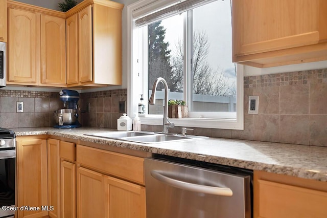 kitchen featuring light brown cabinetry, a healthy amount of sunlight, appliances with stainless steel finishes, and a sink