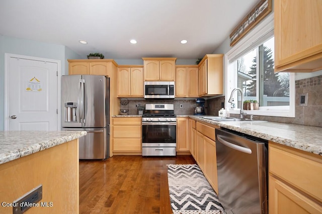 kitchen with dark wood-type flooring, light brown cabinetry, a sink, appliances with stainless steel finishes, and decorative backsplash