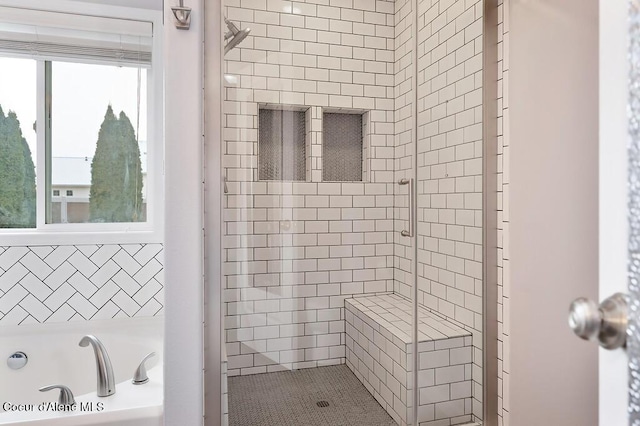 bathroom with a shower stall and a garden tub