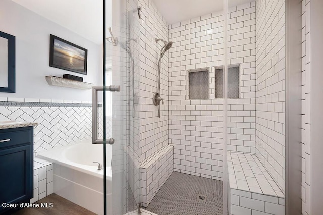 full bath featuring a wainscoted wall, tile walls, a bath, and a shower stall