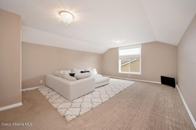 unfurnished bedroom featuring baseboards, lofted ceiling, and carpet