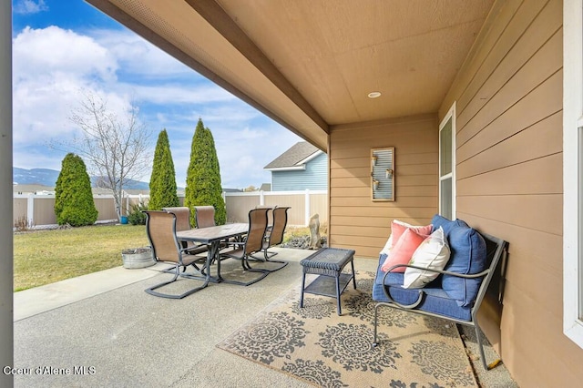 view of patio featuring a fenced backyard, outdoor dining space, and a mountain view