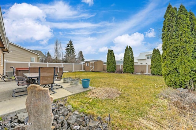 view of yard featuring outdoor dining area, a fenced backyard, a storage shed, a patio area, and an outdoor structure