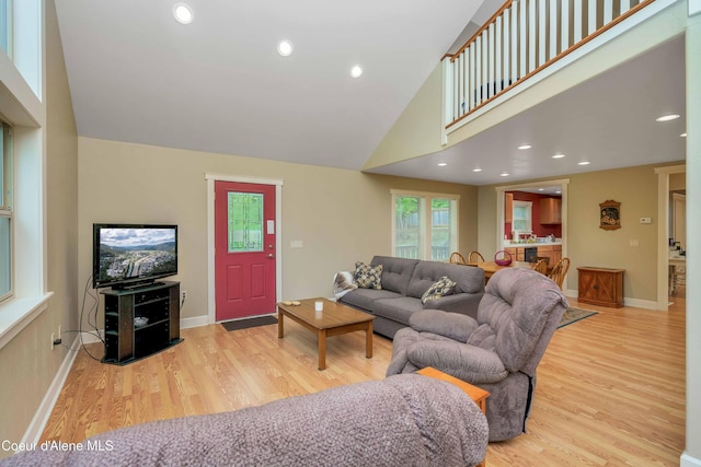 living area featuring recessed lighting, wood finished floors, baseboards, and high vaulted ceiling