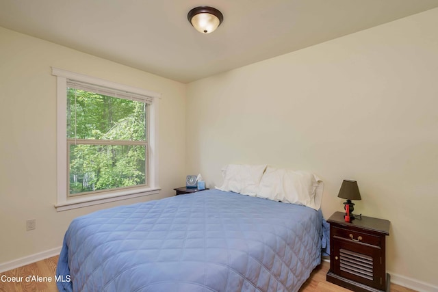 bedroom with baseboards and wood finished floors