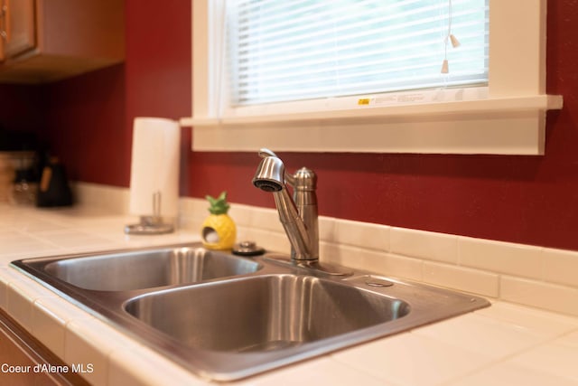 interior details with tile counters and a sink