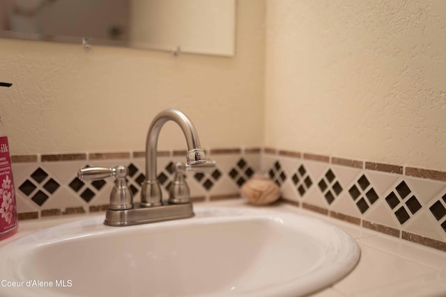 details with a sink and a textured wall