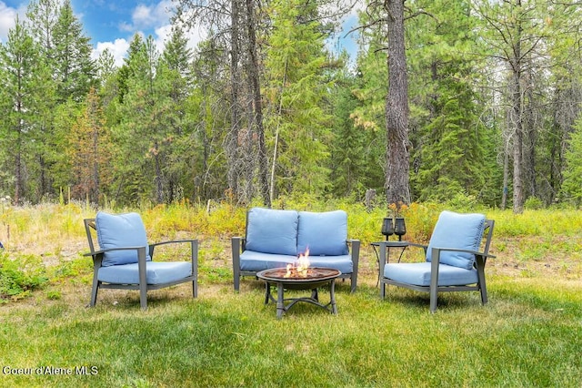 view of yard with a view of trees and a fire pit