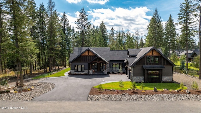 view of front of house with stone siding and a front lawn