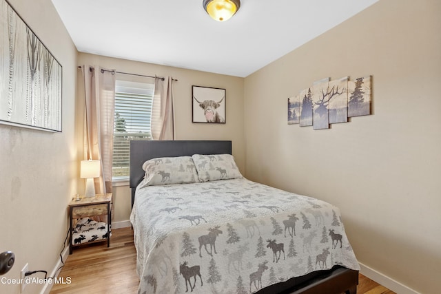 bedroom featuring wood finished floors and baseboards