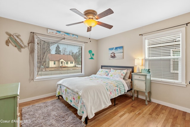 bedroom with ceiling fan, baseboards, and wood finished floors